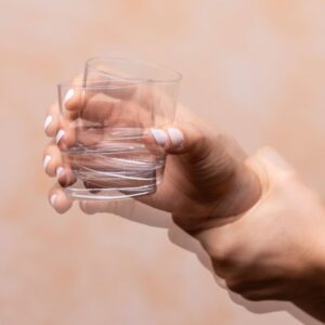 Um estudo publicado em julho de 2026 na revista científica Genes & Diseases apresenta novos resultados sobre a utilização de células estaminais mesenquimais derivadas do cordão umbilical (hUC-MSCs) em pessoas com doença de Parkinson. Os investigadores observaram melhorias em diferentes parâmetros clínicos e identificaram mecanismos biológicos que poderão ajudar a explicar o potencial destas células na proteção e recuperação do sistema nervoso. Um estudo clínico com 35 pessoas com Parkinson A investigação combinou um ensaio clínico exploratório em humanos com estudos laboratoriais e num modelo animal da doença de Parkinson. No ensaio clínico participaram 35 pessoas, com uma idade média de aproximadamente 68 anos e uma duração média da doença de cerca de sete anos. Os participantes receberam quatro administrações de células estaminais mesenquimais humanas provenientes do cordão umbilical ao longo de um mês, através de administração intravenosa e intratecal. Os investigadores avaliaram posteriormente diferentes aspetos da doença, incluindo sintomas motores, equilíbrio, capacidade para realizar atividades diárias, função cognitiva, ansiedade, depressão e qualidade do sono. Melhorias observadas em diferentes sintomas Após o tratamento, foram registadas melhorias estatisticamente significativas em várias escalas utilizadas na avaliação da doença de Parkinson. A escala UPDRS, uma das principais ferramentas utilizadas para avaliar a gravidade dos sintomas da doença, apresentou melhorias a partir das quatro semanas, que se mantiveram nas avaliações posteriores. Também foram observadas alterações favoráveis no equilíbrio, função cognitiva, independência nas atividades diárias, ansiedade, depressão e qualidade do sono. No acompanhamento realizado um ano após o tratamento, os investigadores reportaram, entre outros resultados, uma redução de 26,1% na pontuação UPDRS e uma melhoria em diferentes indicadores relacionados com equilíbrio, cognição e qualidade de vida. Os exames de ressonância magnética também revelaram um aumento da área e da intensidade do sinal de neuromelanina na substância negra, uma região cerebral particularmente afetada na doença de Parkinson e onde se encontram muitos dos neurónios responsáveis pela produção de dopamina. Como poderão atuar estas células? Um dos aspetos mais interessantes desta investigação foi a tentativa de perceber por que razão as células mesenquimais do cordão umbilical poderão produzir estes efeitos. Ao contrário de algumas abordagens de terapia celular que procuram substituir diretamente os neurónios perdidos, os investigadores consideram que a ação destas células poderá estar relacionada sobretudo com os fatores que libertam para o ambiente envolvente. As células mesenquimais possuem propriedades imunomoduladoras, anti-inflamatórias e neuroprotetoras e libertam diferentes moléculas e vesículas extracelulares capazes de participar na comunicação entre células. Neste estudo, as análises do líquido cefalorraquidiano e os estudos realizados em modelos animais apontaram para a participação de uma proteína denominada NCS1 (Neuronal Calcium Sensor 1) e para a ativação de vias relacionadas com o sistema endocanabinoide. Estas alterações poderão contribuir para regular a inflamação no cérebro e criar um ambiente mais favorável à sobrevivência dos neurónios. Os investigadores observaram também uma redução das células microgliais associadas aos processos de neuroinflamação nos modelos experimentais tratados com células mesenquimais. Segurança e próximos passos Durante o estudo, não foram registados eventos adversos relacionados com a administração das células mesenquimais, incluindo durante o acompanhamento realizado após o tratamento. Apesar dos resultados positivos, é importante interpretar estas conclusões com prudência. Este foi um ensaio clínico exploratório, aberto e de braço único, ou seja, todos os participantes receberam o tratamento e não existiu um grupo de controlo ou placebo com o qual comparar os resultados. Desta forma, o estudo não permite ainda concluir que as células estaminais do cordão umbilical constituem um tratamento eficaz para a doença de Parkinson. Os próprios investigadores salientam a necessidade de realizar ensaios clínicos randomizados e controlados, com um maior número de participantes, para confirmar a segurança e a eficácia da abordagem. Ainda assim, os resultados acrescentam novas evidências à investigação sobre o potencial das células mesenquimais provenientes do tecido do cordão umbilical na medicina regenerativa, particularmente no contexto das doenças neurodegenerativas.
